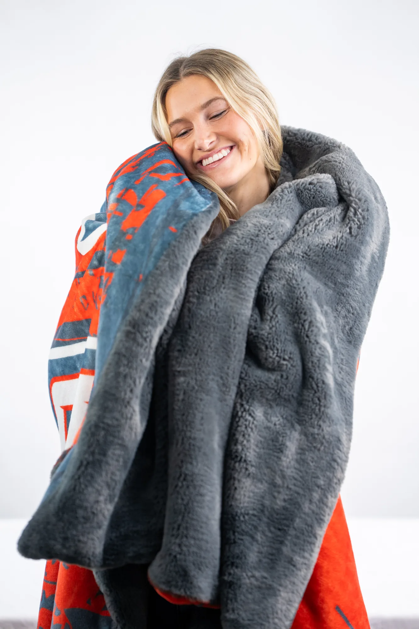 A person wrapped head to shoulder in a heavy, ultra-soft custom plush keepsake blanket in warm light
